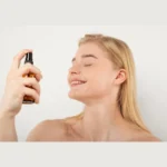 Woman using facial mist for hydration in UAE summer