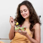 Woman eating healthy salad for better skin in UAE summer